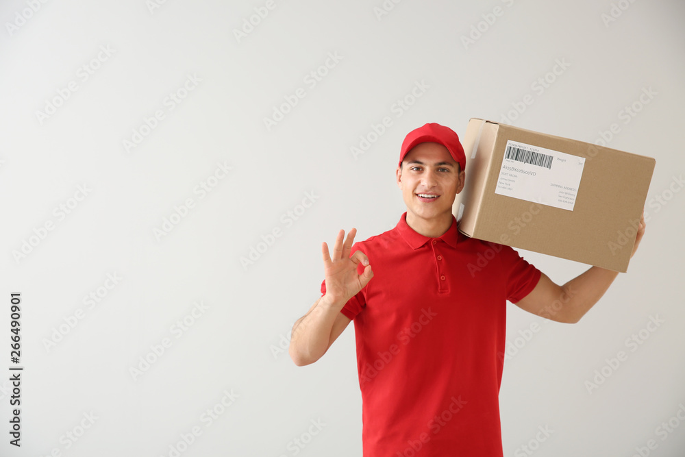 Delivery man with box showing OK on white background Delivery man with box showing OK on white background