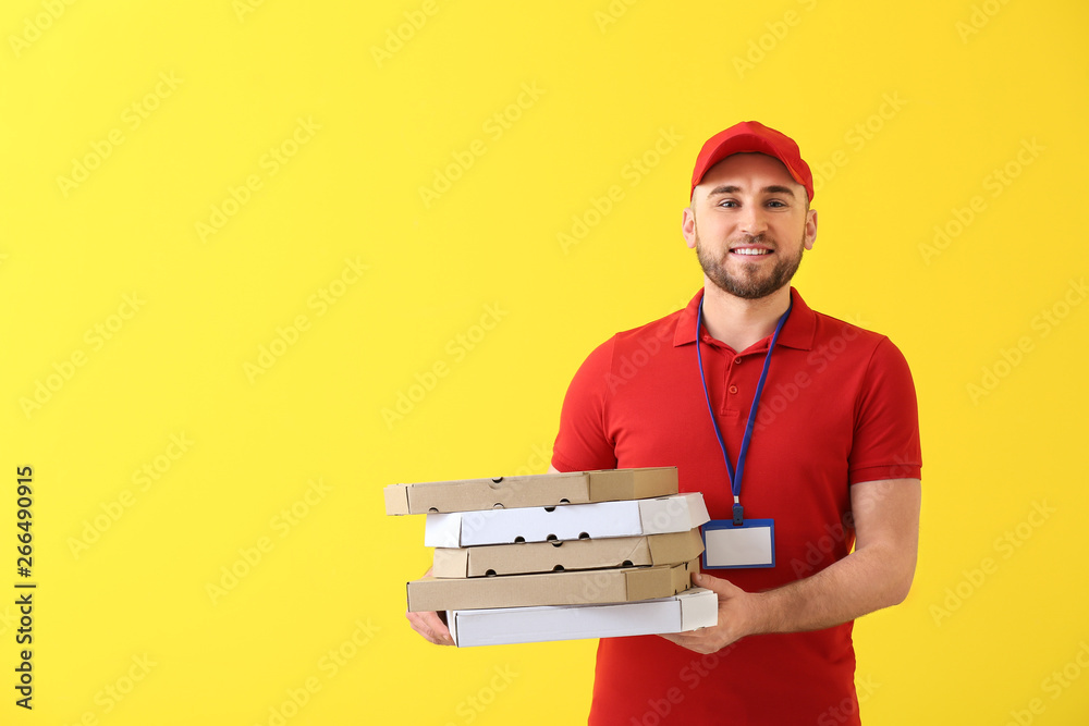Handsome delivery man with pizza boxes on color background Handsome delivery man with pizza boxes on color background