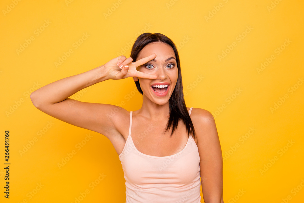 Close up photo beautiful funky she her lady laughter cheerful show v-sign near eye say hi hello friends relatives people wear casual pastel tank-top outfit clothes isolated yellow bright background Close up photo beautiful funky she her lady laughter cheerful show v-sign near eye say hi hello friends relatives people wear casual pastel tank-top outfit clothes isolated yellow bright background