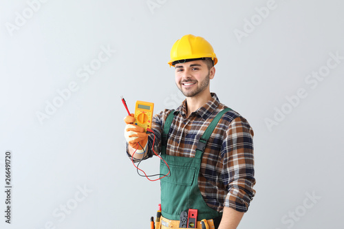 Male electrician on light background photo