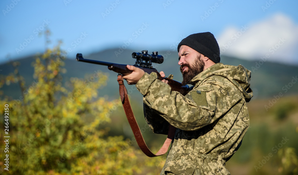 Fototapeta premium Hunting and trapping seasons. Hunting masculine hobby. Man brutal gamekeeper nature background. Hunter hold rifle. Bearded hunter spend leisure hunting. Focus and concentration of experienced hunter