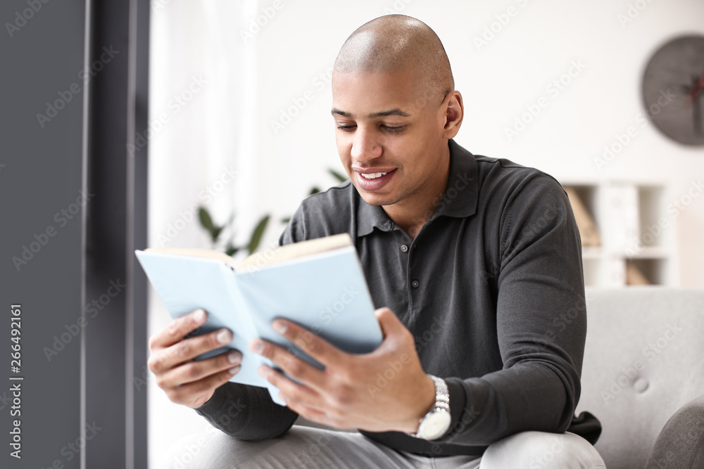 African-American man reading book at home African-American man reading book at home