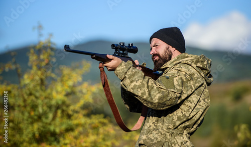 Hunting and trapping seasons. Hunting masculine hobby. Man brutal gamekeeper nature background. Hunter hold rifle. Bearded hunter spend leisure hunting. Focus and concentration of experienced hunter