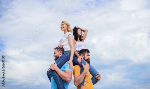 Getting away from everything. Loving couples enjoy fun together. Playful couples in love smiling on cloudy sky. Happy men piggybacking their girlfriends. Loving couples having fun activities outdoor