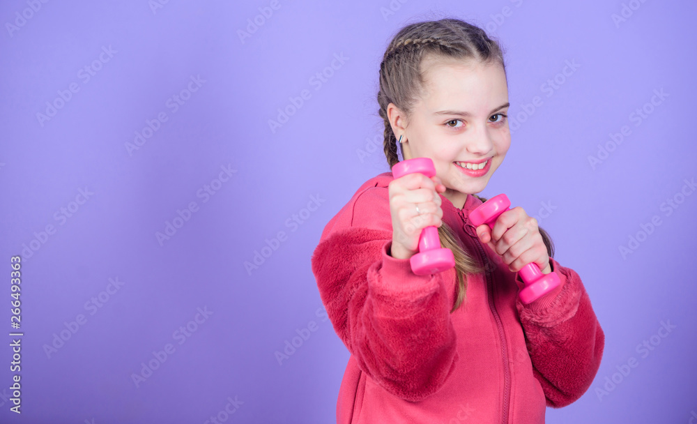 Happy child sportsman with barbell. workout of small girl hold dumbbell. weight lifting for muscules. Childhood activity. Fitness diet for energy health. Sport success. workout equipment. workout gym Happy child sportsman with barbell. workout of small girl hold dumbbell. weight lifting for muscules. Childhood activity. Fitness diet for energy health. Sport success. workout equipment. workout gym
