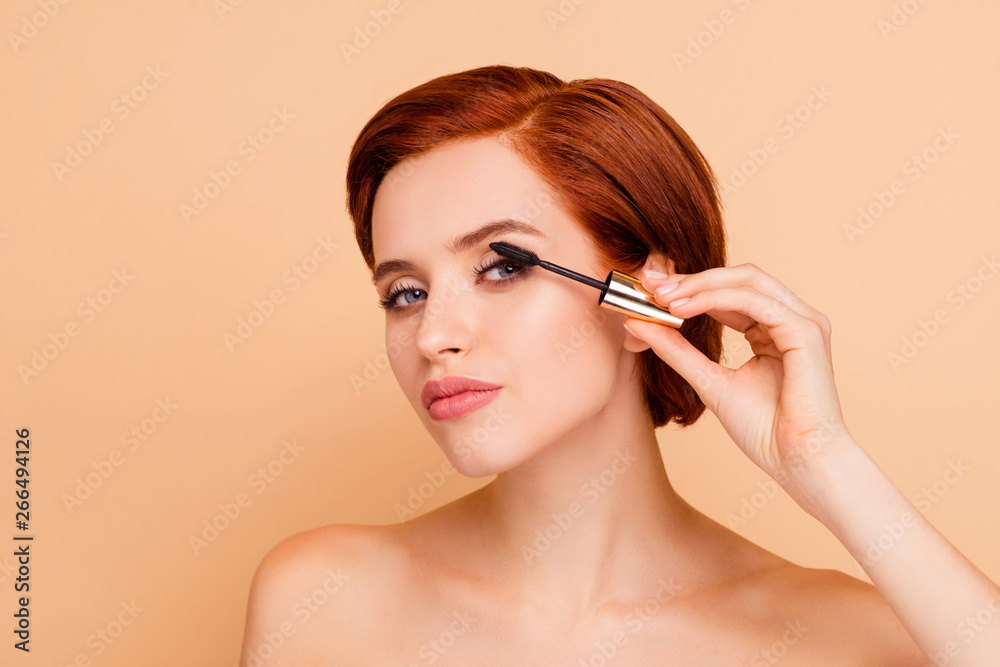Close-up portrait of nice confident content gorgeous lovely attractive glamorous well-groomed candid peaceful girl applying trendy stylish black mascara isolated over beige pastel background