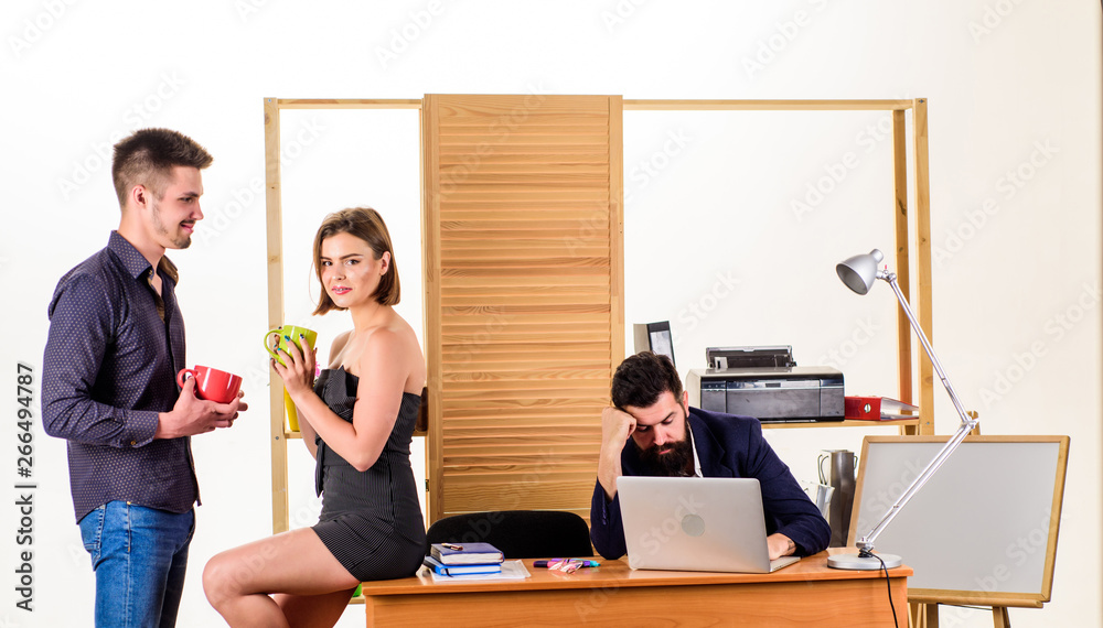 Modern lunch. Young colleagues talking during work lunch. Business partners talking on lunch break while angry colleague working in background. Two coworkers having tea or coffee for lunch Modern lunch. Young colleagues talking during work lunch. Business partners talking on lunch break while angry colleague working in background. Two coworkers having tea or coffee for lunch