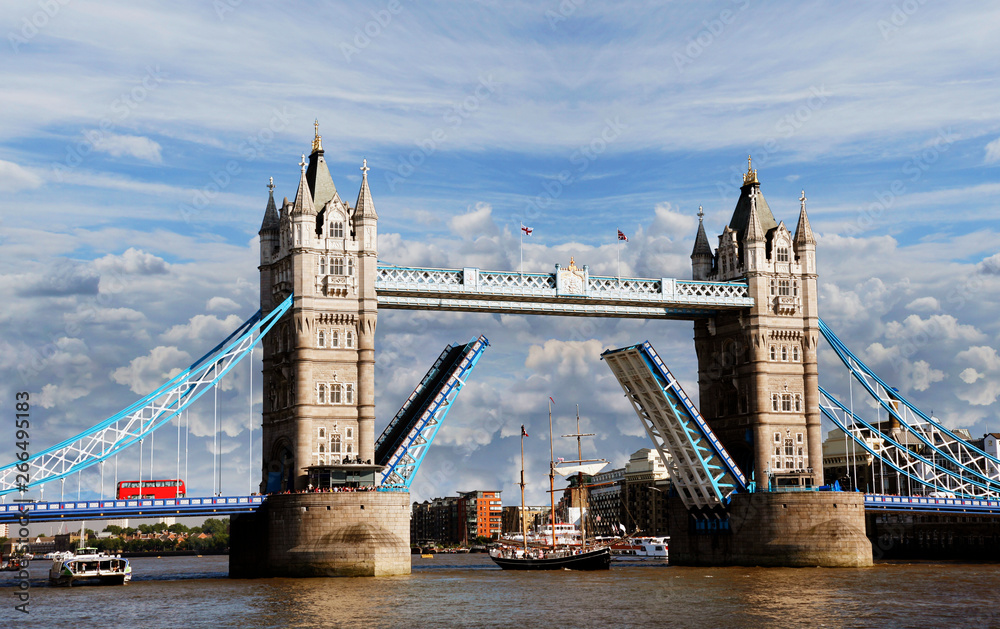 Obraz premium Tower Bridge, lifted over dramatic cloudy sky.