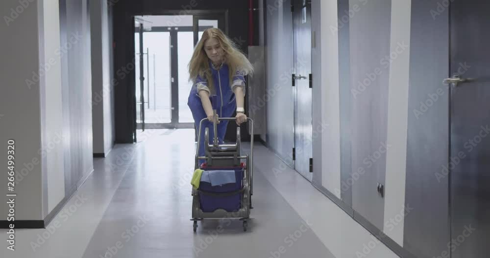 Beautiful charwoman running through office corridor Beautiful charwoman running through office corridor