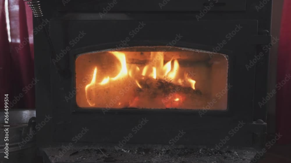 View inside of a stove with burning trunks View inside of a stove with burning trunks