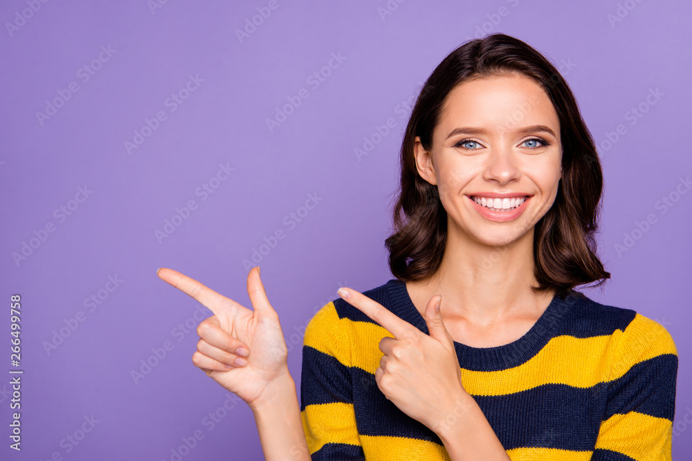 Close up photo beautiful amazing funky she her lady perfect white teeth hold hands arms index fingers indicating side empty space wear blue yellow striped pullover isolated violet purple background Close up photo beautiful amazing funky she her lady perfect white teeth hold hands arms index fingers indicating side empty space wear blue yellow striped pullover isolated violet purple background