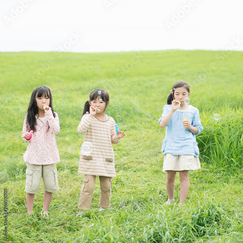 草原でシャボン玉をする小学生