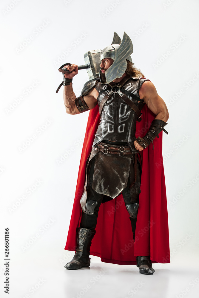Long hair and muscular male model in leather viking's costume with the big hammer cosplaying Thor isolated on white studio background. Full-lenght portrait. Fantasy warrior, antique battle concept. Long hair and muscular male model in leather viking's costume with the big hammer cosplaying Thor isolated on white studio background. Full-lenght portrait. Fantasy warrior, antique battle concept.