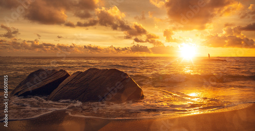 Eindrucksvoller Sonnenaufgang am Meer mit Person am Horizont photo