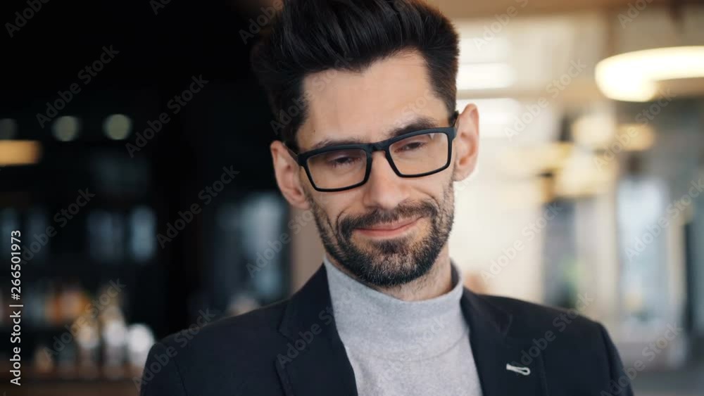 Close-up portrait of attractive bearded brunet successful miffle-aged businessman smiling standing in cafe alone and looking at camera. People and emotions concept. Close-up portrait of attractive bearded brunet successful miffle-aged businessman smiling standing in cafe alone and looking at camera. People and emotions concept.