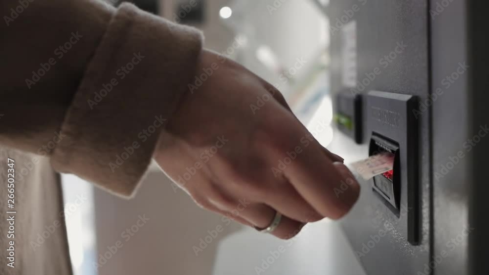 A woman's hand makes a banknote to the ATM A woman's hand makes a banknote to the ATM