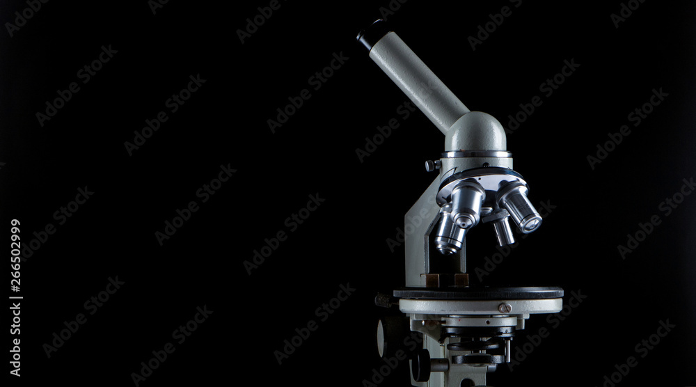 white microscope on dark background. Close up white microscope on dark background. Close up
