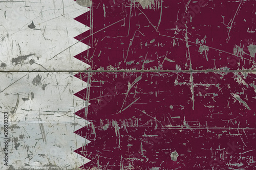 Grunge Qatar flag on old scratched wooden surface. National vintage background.