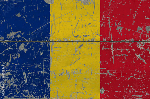 Grunge Romania flag on old scratched wooden surface. National vintage background.