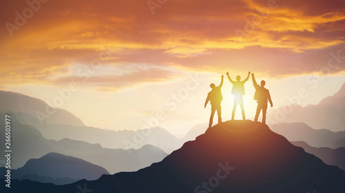 Group of peoples on mountains top in winner pose photo