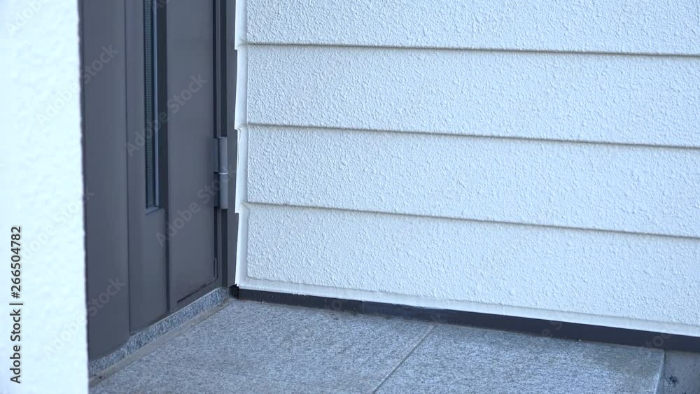 A door opens and legs of a parsons enter the entrance the house on daytime with a calm movement. Camera fix, angle high, medium closeup shoot. 4K 24fps (TOKYO, JAPAN - 15th March 2019). A door opens and legs of a parsons enter the entrance the house on daytime with a calm movement. Camera fix, angle high, medium closeup shoot. 4K 24fps (TOKYO, JAPAN - 15th March 2019).