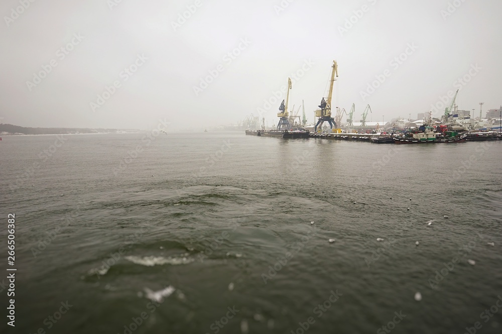 ferry trip in Lithuania to the city of Klaipeda in the winter season overlooking the bay with access to the Baltic Sea, and with cranes in the port