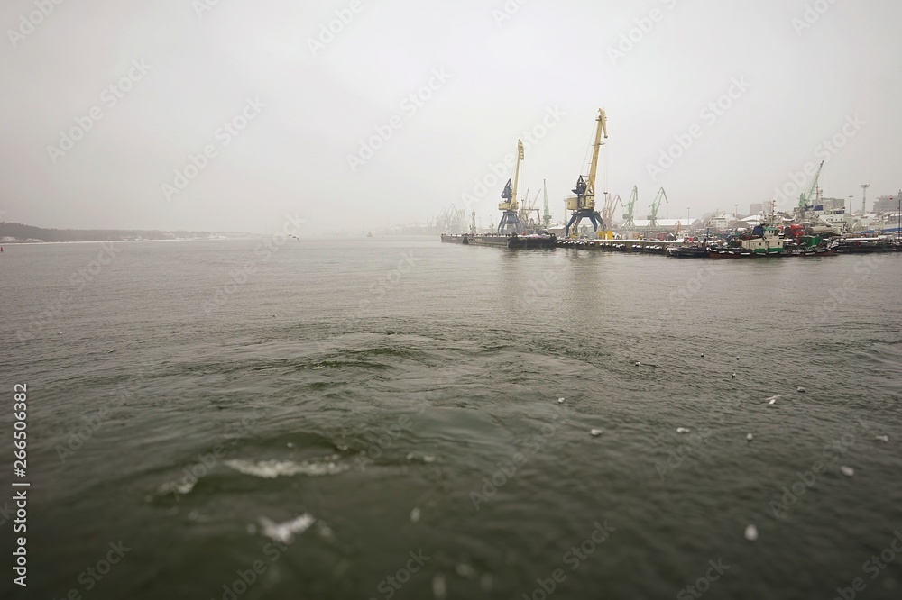ferry trip in Lithuania to the city of Klaipeda in the winter season overlooking the bay with access to the Baltic Sea, and with cranes in the port ferry trip in Lithuania to the city of Klaipeda in the winter season overlooking the bay with access to the Baltic Sea, and with cranes in the port