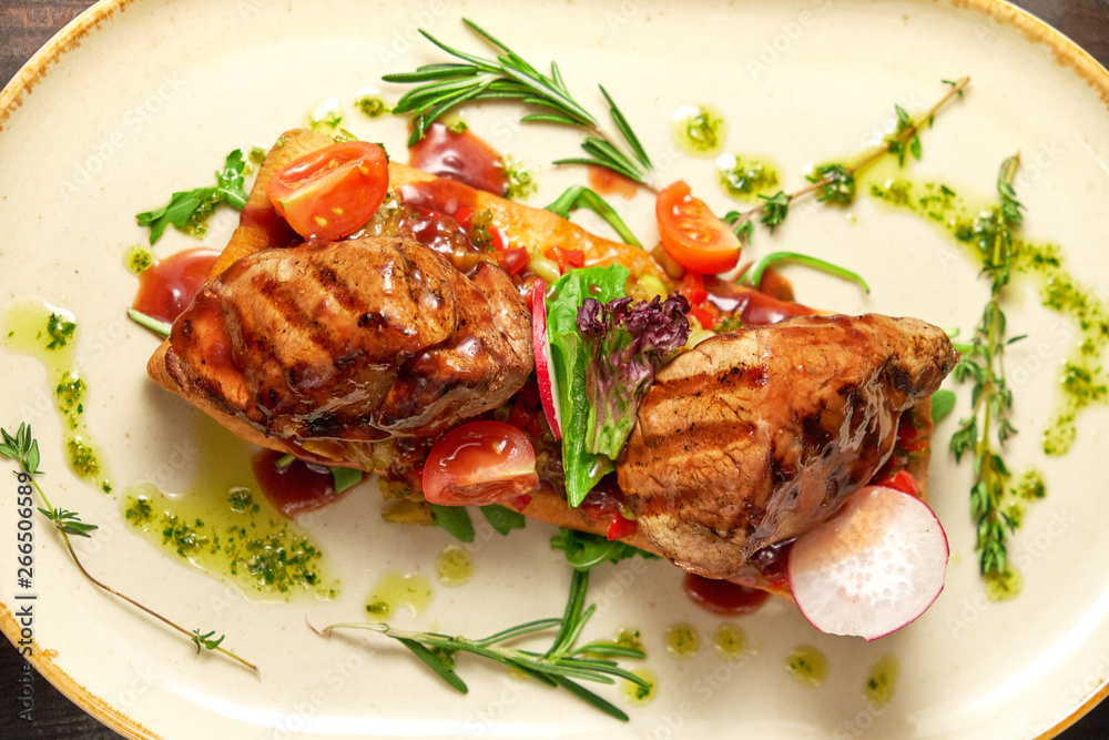 Grilled meat on pita bread on a bright oval plate. Dark wooden background. Restaurant menu Grilled meat on pita bread on a bright oval plate. Dark wooden background. Restaurant menu