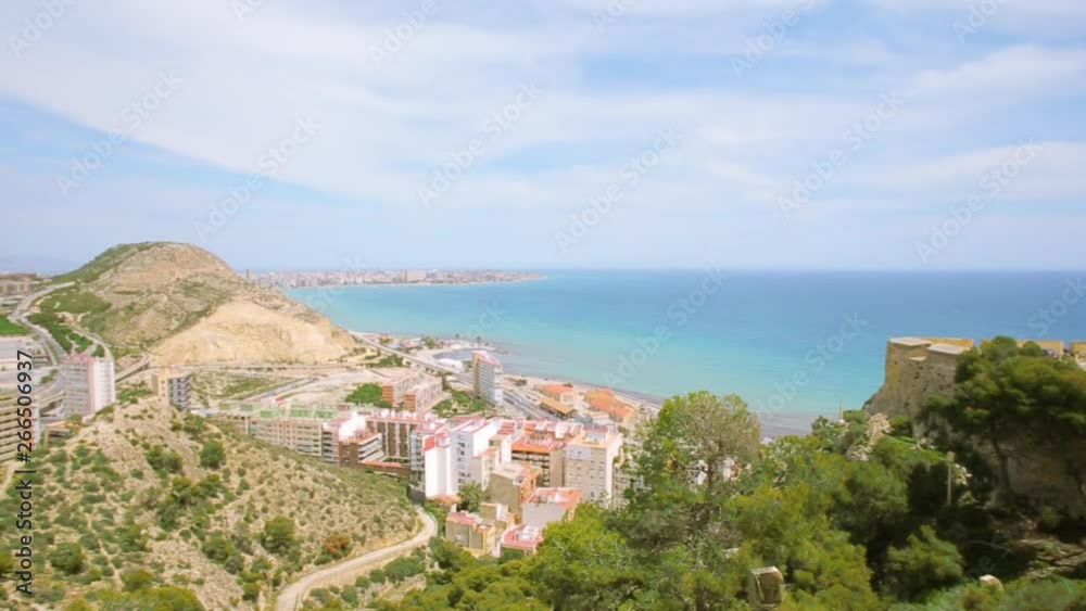Panoramic view on Alicante city from the place on Mount Benacantil, near the Castle of Santa Barbara, ancient old building in the center of town. Sunny spring day. Spain, Valencia region Panoramic view on Alicante city from the place on Mount Benacantil, near the Castle of Santa Barbara, ancient old building in the center of town. Sunny spring day. Spain, Valencia region