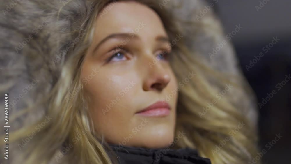Blonde girl with blue eyes and winter jacket looks into the sky. Blonde girl with blue eyes and winter jacket looks into the sky.