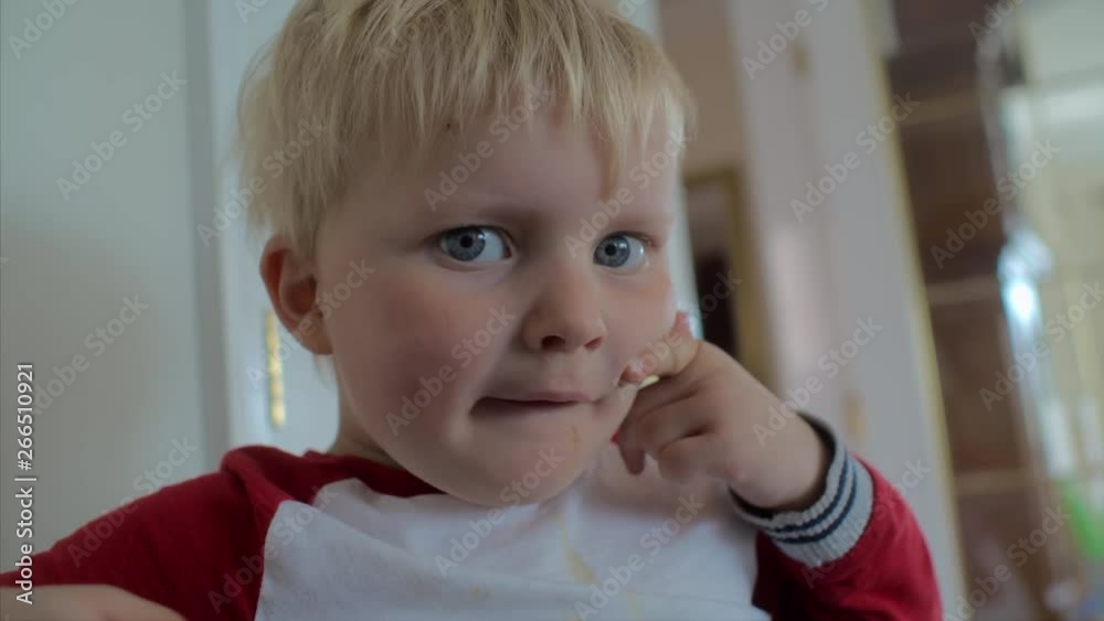A cute child with blonde hair and blue eyes pulling a smile with his fingers. CLOSE UP. A cute child with blonde hair and blue eyes pulling a smile with his fingers. CLOSE UP.