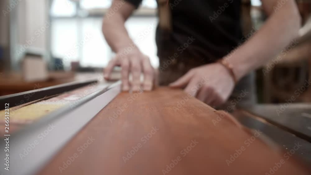 Wood worker cuts lumber on table saw. Wood worker cuts lumber on table saw.