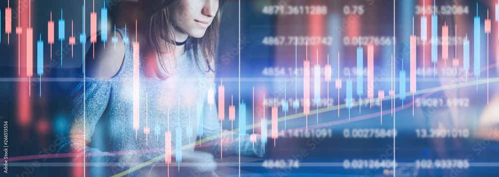 Fototapeta premium Young female model working at night modern office.Technical price graph and indicator, red and green candlestick chart and stock trading computer screen background. Double exposure.Wide
