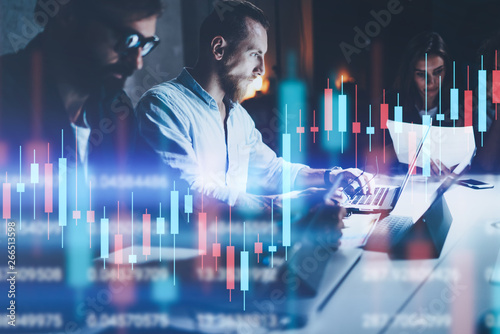 Business team working together at night office.Technical price graph and indicator, red and green candlestick chart and stock trading computer screen background. Double exposure.