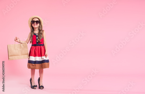 little fashionista on a colored background in mom's shoes