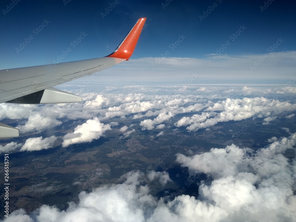 wing of an airplane flying above the clouds wing of an airplane flying above the clouds