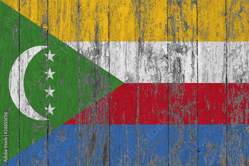 Flag of Comoros painted on worn out wooden texture background. photo