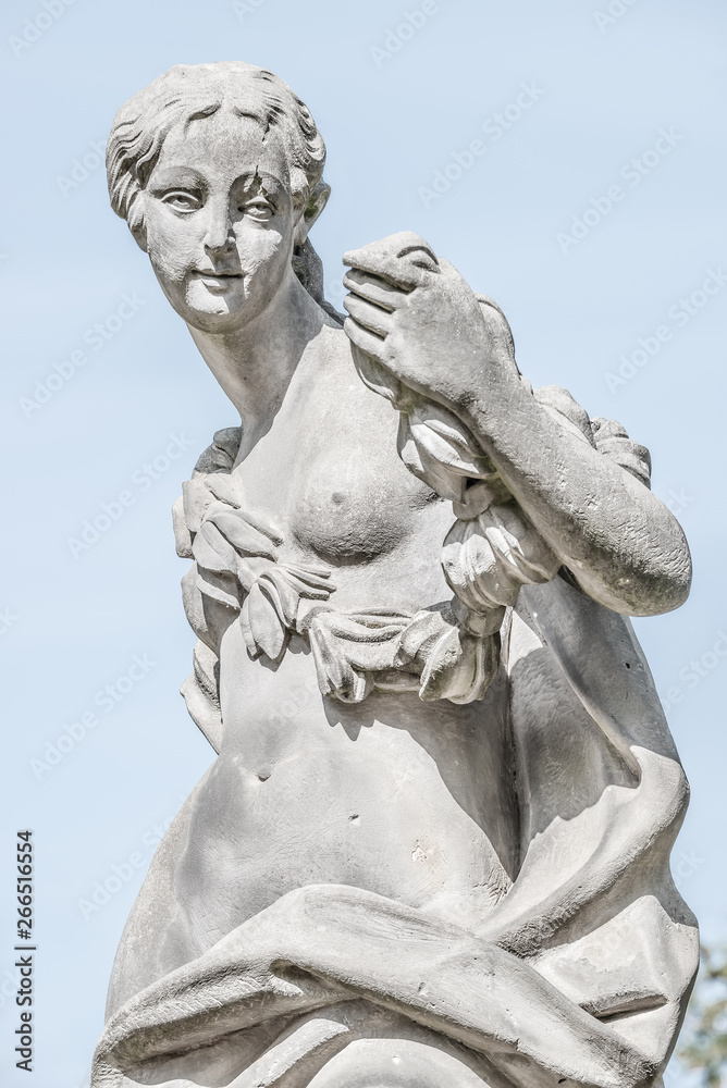 Ancient statue covered with moss and lichen of a sensual renaissance era woman in Potsdam, Germany Ancient statue covered with moss and lichen of a sensual renaissance era woman in Potsdam, Germany