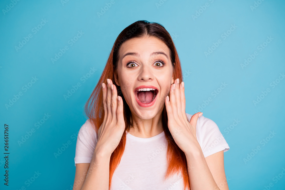 Close up photo  charming pretty youth lovely astonished impressed by incredible novelty  rumor gossip place hands palms near cheeks face open mouth wonder shout isolated  t-shirt  blue background