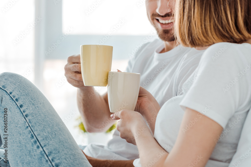 Cropped view of couple drinking coffee at home