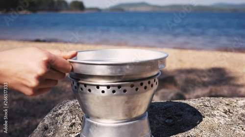 Close up of girl putting on the lid of a Trangia portable stove. Part five. 60 fps Slowmotion. photo