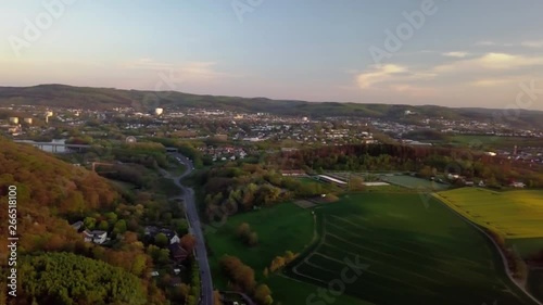 AERIAL, camera panning showing a city with a wooded area in its outskirts with abundant and green vegetation