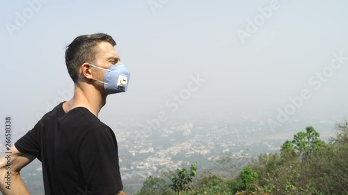 Young man wearing  face mask in air pollution. A highly toxic polluted air quality index reached 300 in Chiang- Mai city of Thailand photo