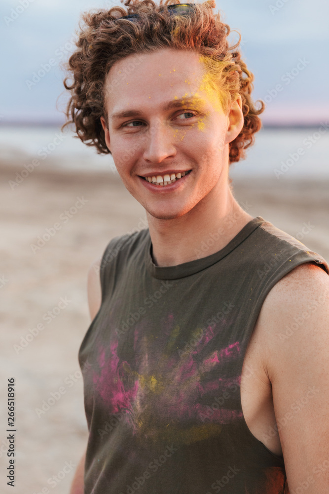 Cheerful young man standing at the beach Cheerful young man standing at the beach
