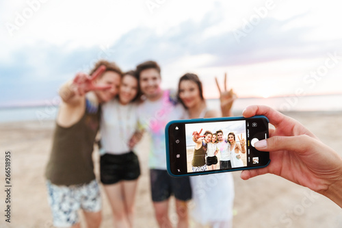 Group of a cheerful young friends having fun at the beach photo