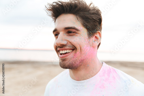 Cheerful young man standing at the beach