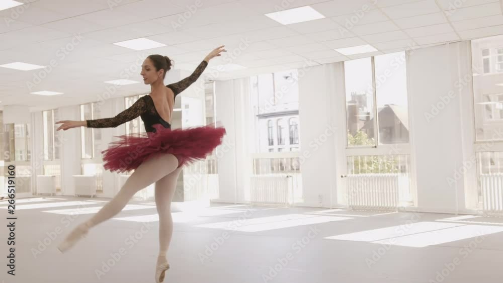 Slow motion arc shot of a ballerina practicing her pointe technique