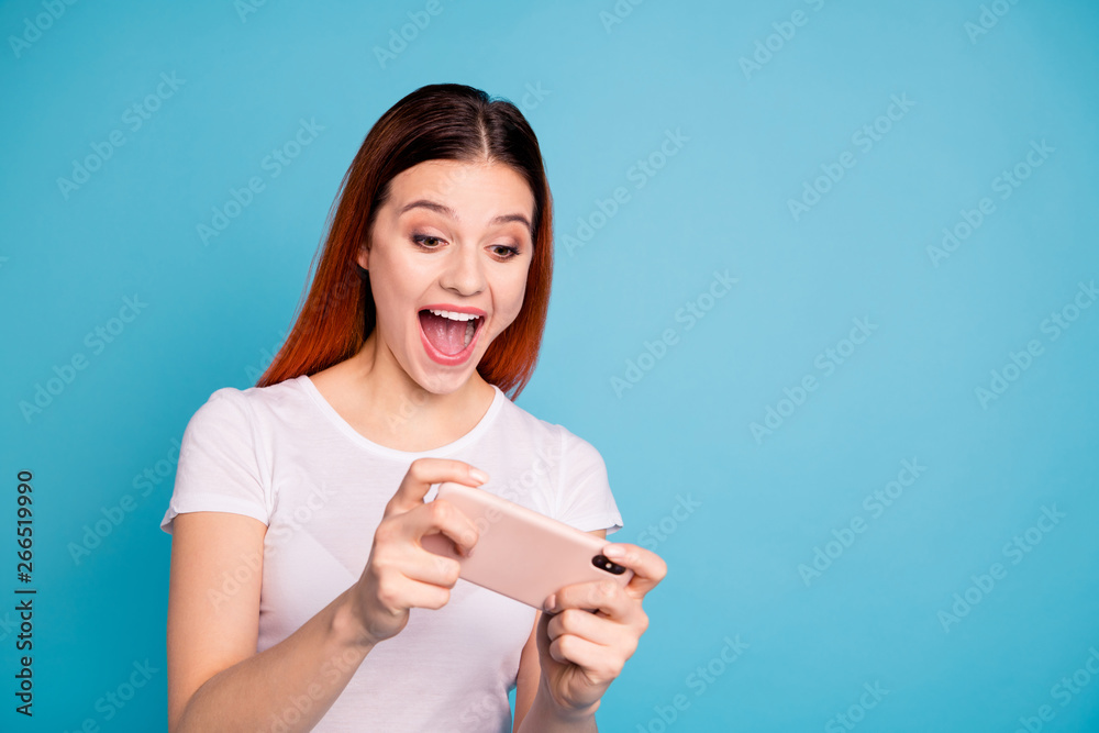 Close-up portrait of her she nice attractive winsome lovely cheerful cheery lady wearing white t-shirt having fun game device gadget isolated over bright vivid shine blue background Close-up portrait of her she nice attractive winsome lovely cheerful cheery lady wearing white t-shirt having fun game device gadget isolated over bright vivid shine blue background