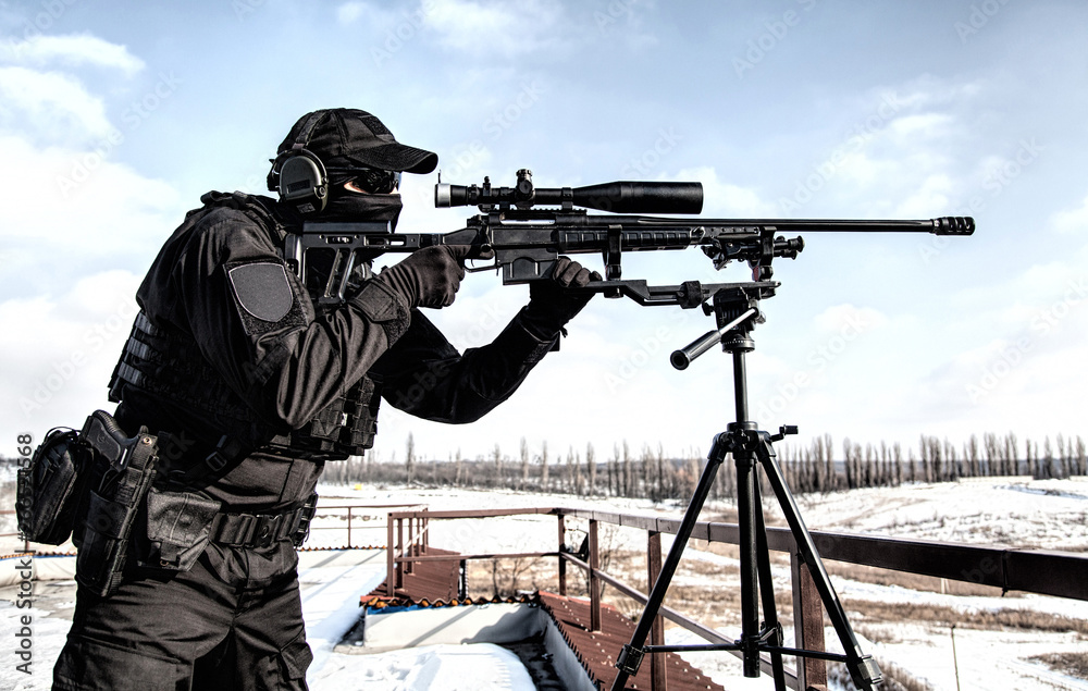 Equipped police SWAT sniper shooting with rifle