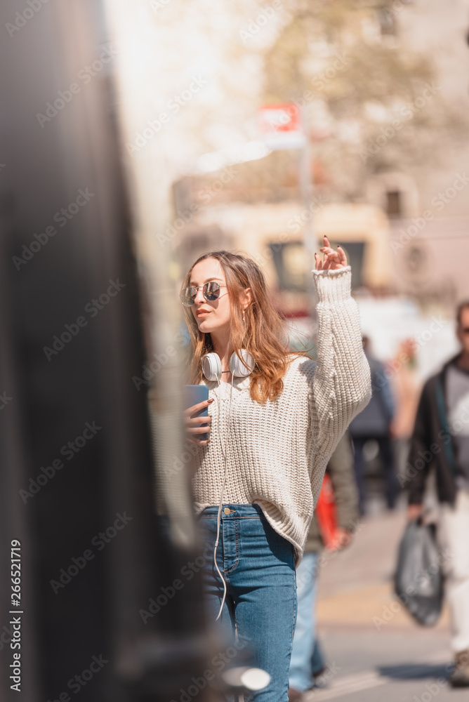 Beautiful woman looks for a taxi at street